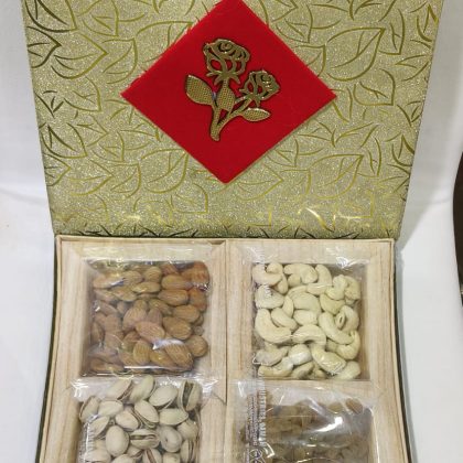 A classy golden gift box featuring four premium dry fruits packed for festive and elegant gifting.